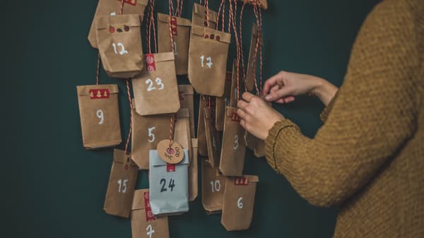 En person fixar med en DIY julkalender som hänger på en galge.
