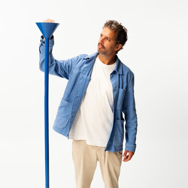 En person håller den ena handen på en blå lampa. 