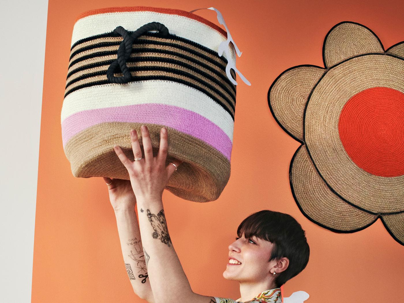 En person håller upp en färgglad tygkorg över huvudet.