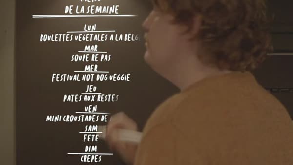 En person laver en madplan på en kridttavle.