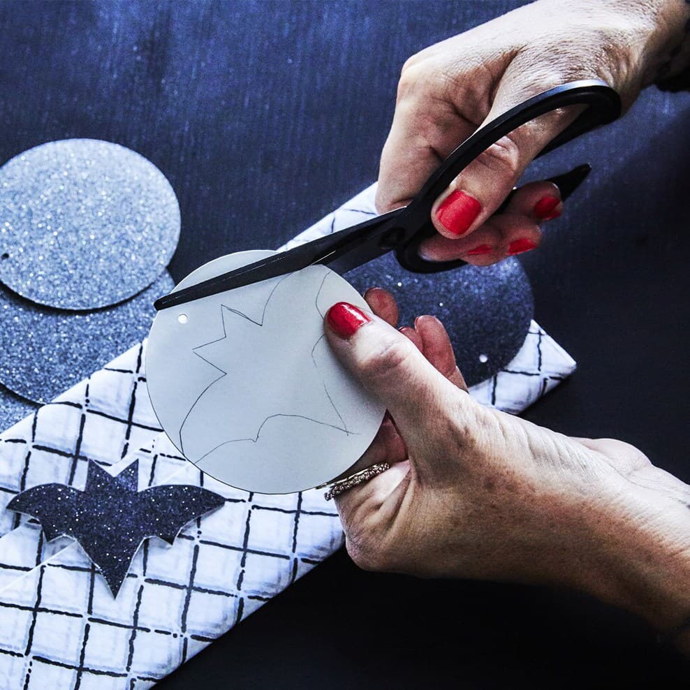 En person som halloweenpysslar. DYI fladdermus.