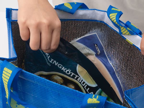 En person som packar i IKEA matvaror i en IKEA kasse