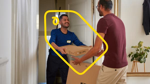 En person som tar emot ett IKEA paket från en annan person i blått.