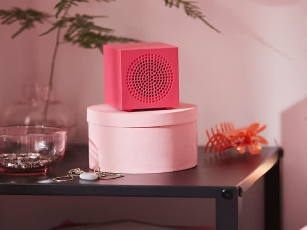 En rosa högtalare på ett bord.