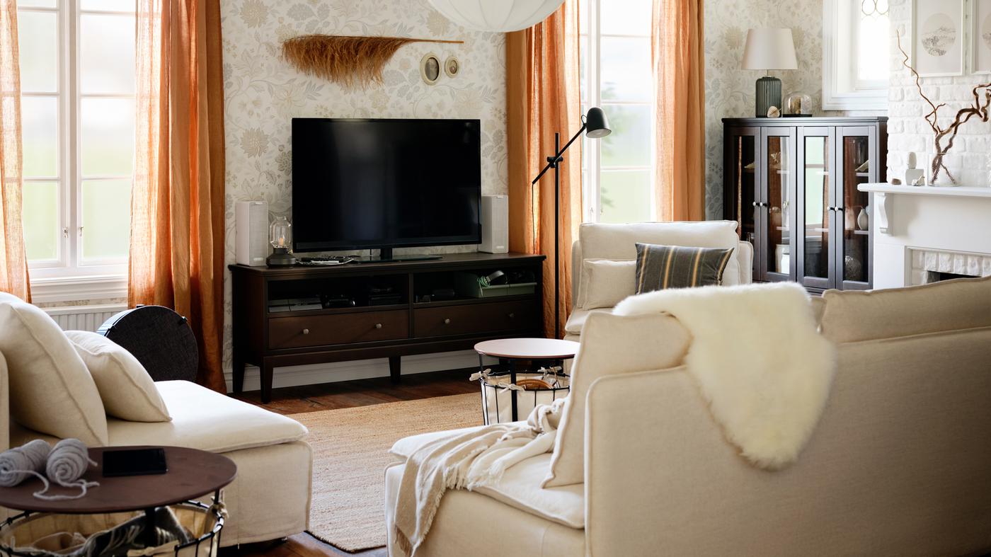 Én treseters og to enseters SÖDERHAMN sofaseksjoner rundt en TV-benk mellom to vinduer med mørk beige gardiner.