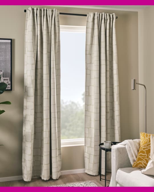En un living todos los textiles combinan en tonos beige. Destacan unas cortinas blacout de tela a medio cerrar.