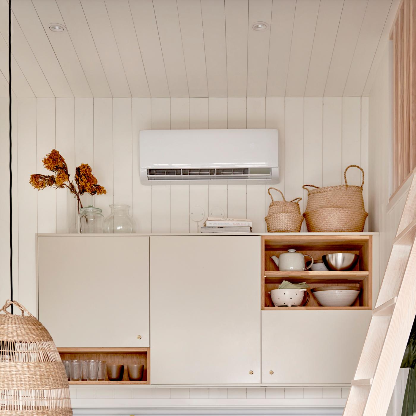 En värmepump ovanför köksluckor i ett sommarstugekök.