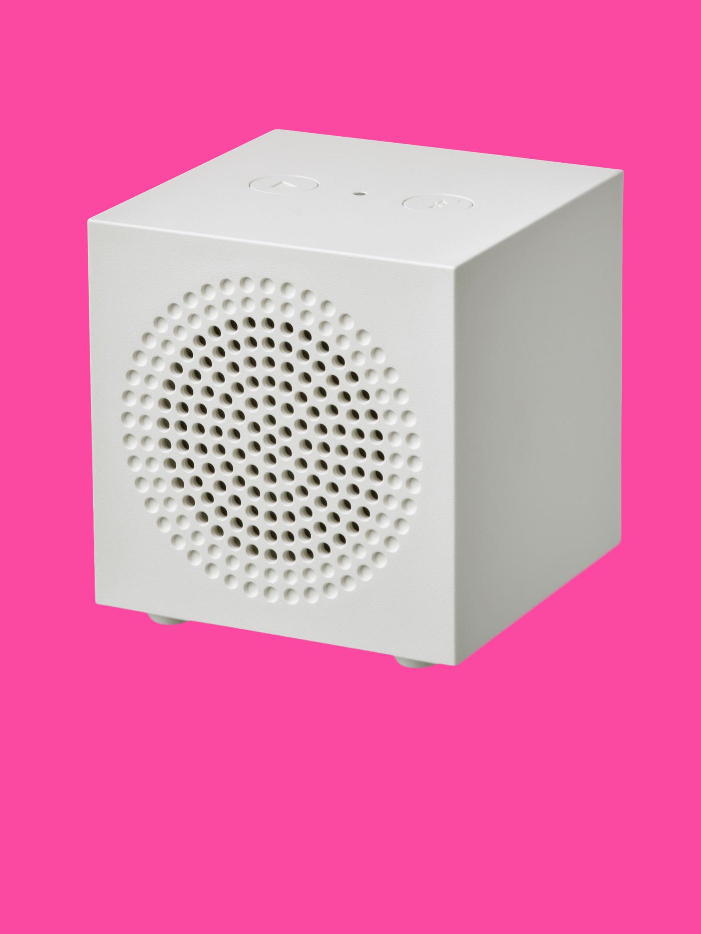 En vit högtalare mot rosa bakgrund.