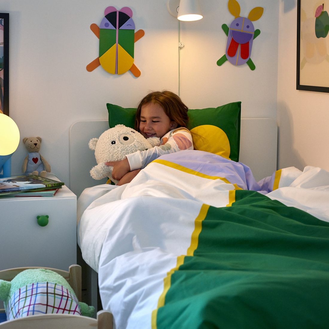 enfant dans un lit qui tient une peluche 