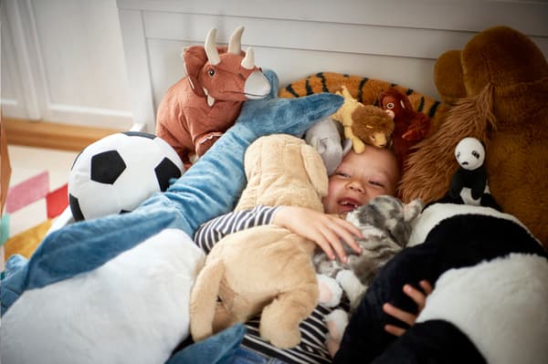 Enfant qui s'amuse avec des peluches IKEA.