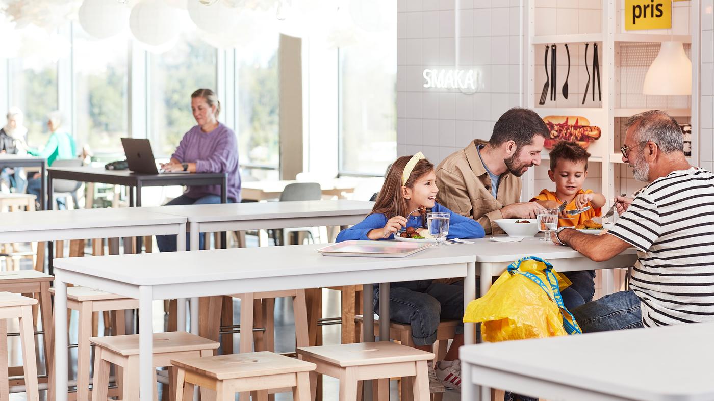 Enfants et parents qui mangent autour d'une table au restaurant IKEA