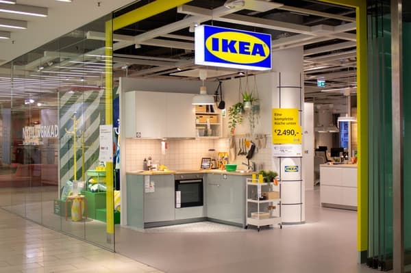 Entrance to an IKEA Planning Studio featuring a display kitchen and a yellow promotional poster
