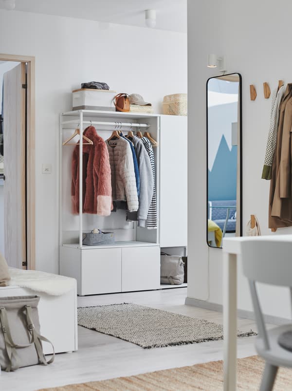 Entrée avec stations ouvertes pour suspendre ou ranger des vêtements, dont une garde-robe PLATSA blanche.
