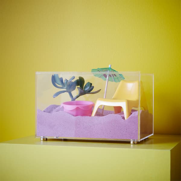 Envie de trouver une utilisation originale à votre boîte vitrée ? Transformez la boîte vitrée BJÖRNARP de chez IKEA en mini-plage pour bureau. Admirez le paysage derrière les parois en acrylique transparent. Pour jouer avec le sable, faites simplement coulisser le couvercle!