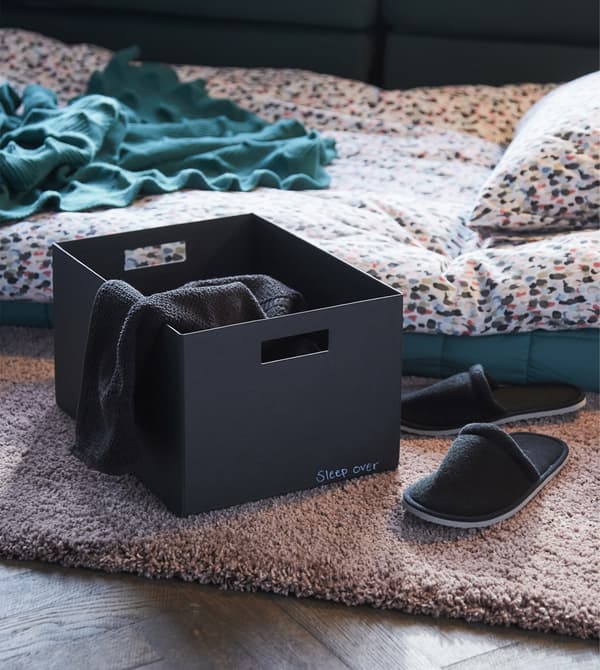 Envie d’idées de décoration intérieure qui feront que vos amis ne voudront plus s’en aller? Préparez-vous à héberger du monde la nuit. Regroupez couverture, pantoufles et bouchons d’oreille dans une boîte, comme cette boîte avec couvercle TJENA en noir de chez IKEA.