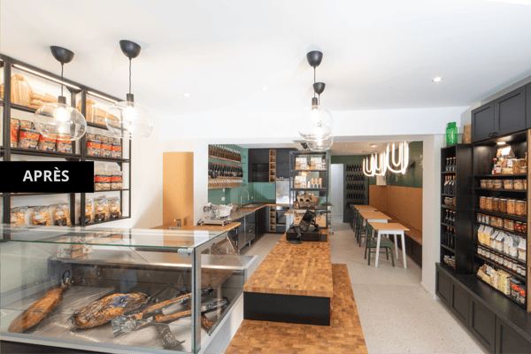 Epicerie fine neuve avec une vitrine pour la viande, un plan de travail en bois et une grande étagère pour exposer les produits de l'épicerie.