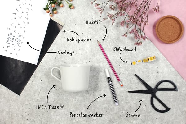 Es ist ein Bild mit einer Schere einem Stift einer Tasse einem Papier einem Klebeband und einen Porcellanmarker. In dem Bild wird gezeigt was man für eine coole DIY Tasse benötigt.
