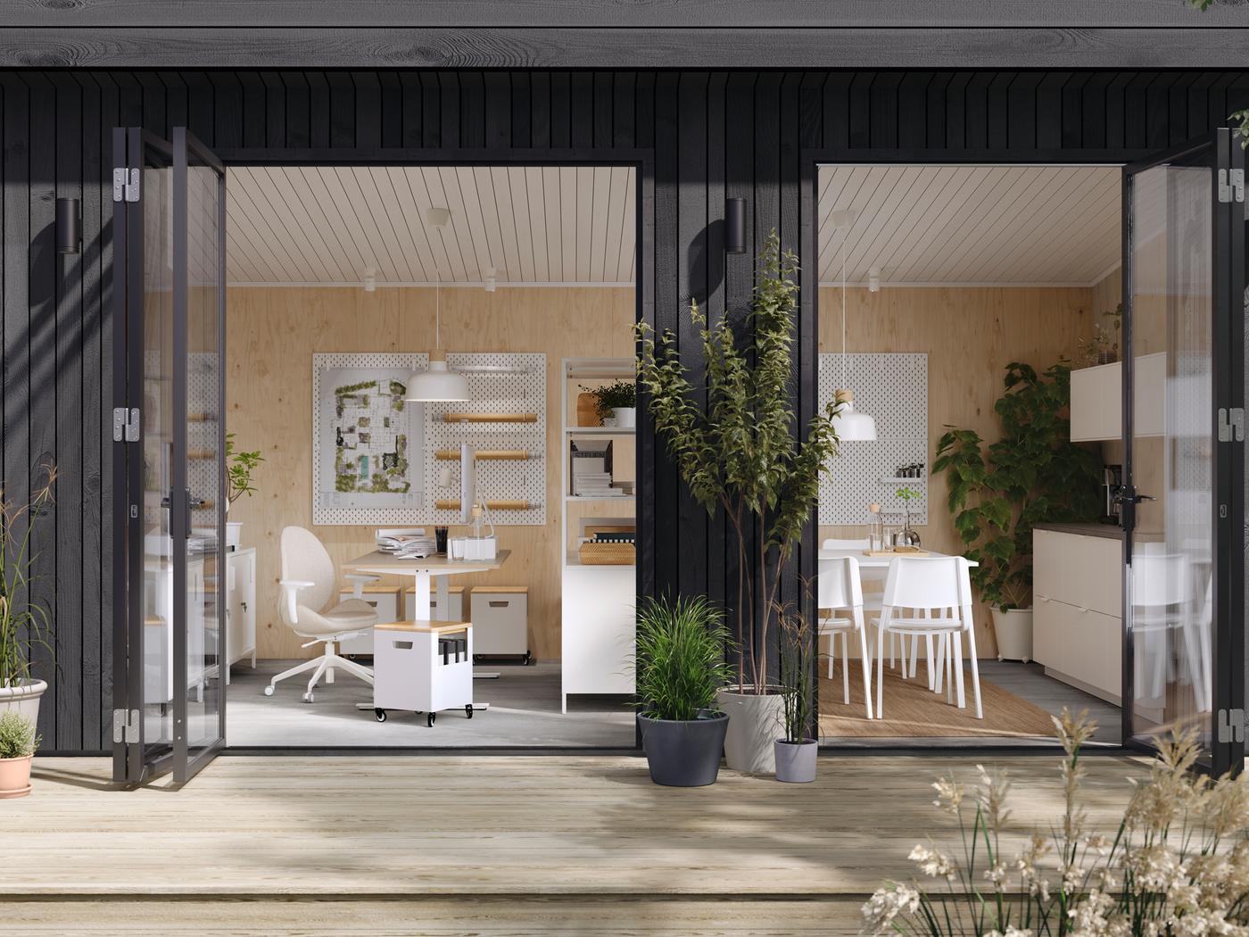 Es ist ein Gartenstudio zu sehen, durch dessen geöffnete Türen ein Arbeitsbereich mit einem TROTTEN Schreibtisch und einem Drehstuhl und offene Regale zu erkennen sind, die als Raumteiler dienen und so die Gemeinschaftsküche vom Arbeitsbereich abtrennen.