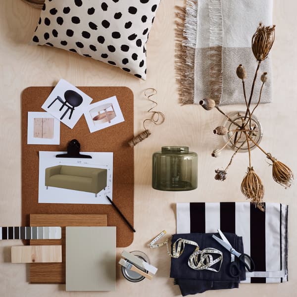 Es ist ein Moodboard mit Bildern von Möbeln auf einer SUSIG Schreibunterlage aus Kork neben einem Kissenbezug, zwei Glasvasen und Farbbeispielen zu sehen. 