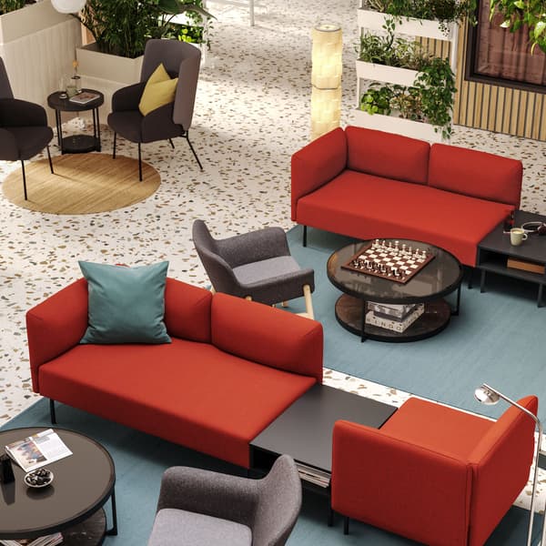 Es ist eine Hotellobby von oben zu sehen. Hier befinden sich zwei Sitzbereiche aus LILLEHEM Sitzelementen und grauen Sesseln auf grossen Teppichen.