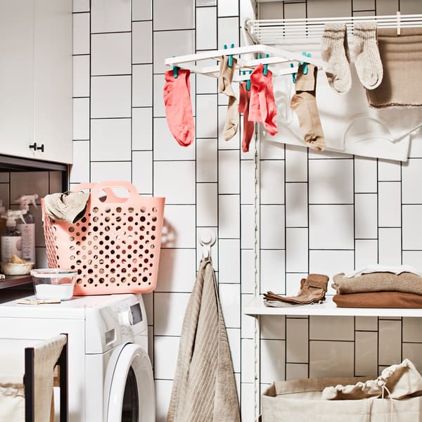 Es ist eine im Badezimmer eingerichtete Waschküche mit Waschmaschine, Aufbewahrung für Wäsche mit Schrank und einer Wäschekombination mit Boden zu sehen.