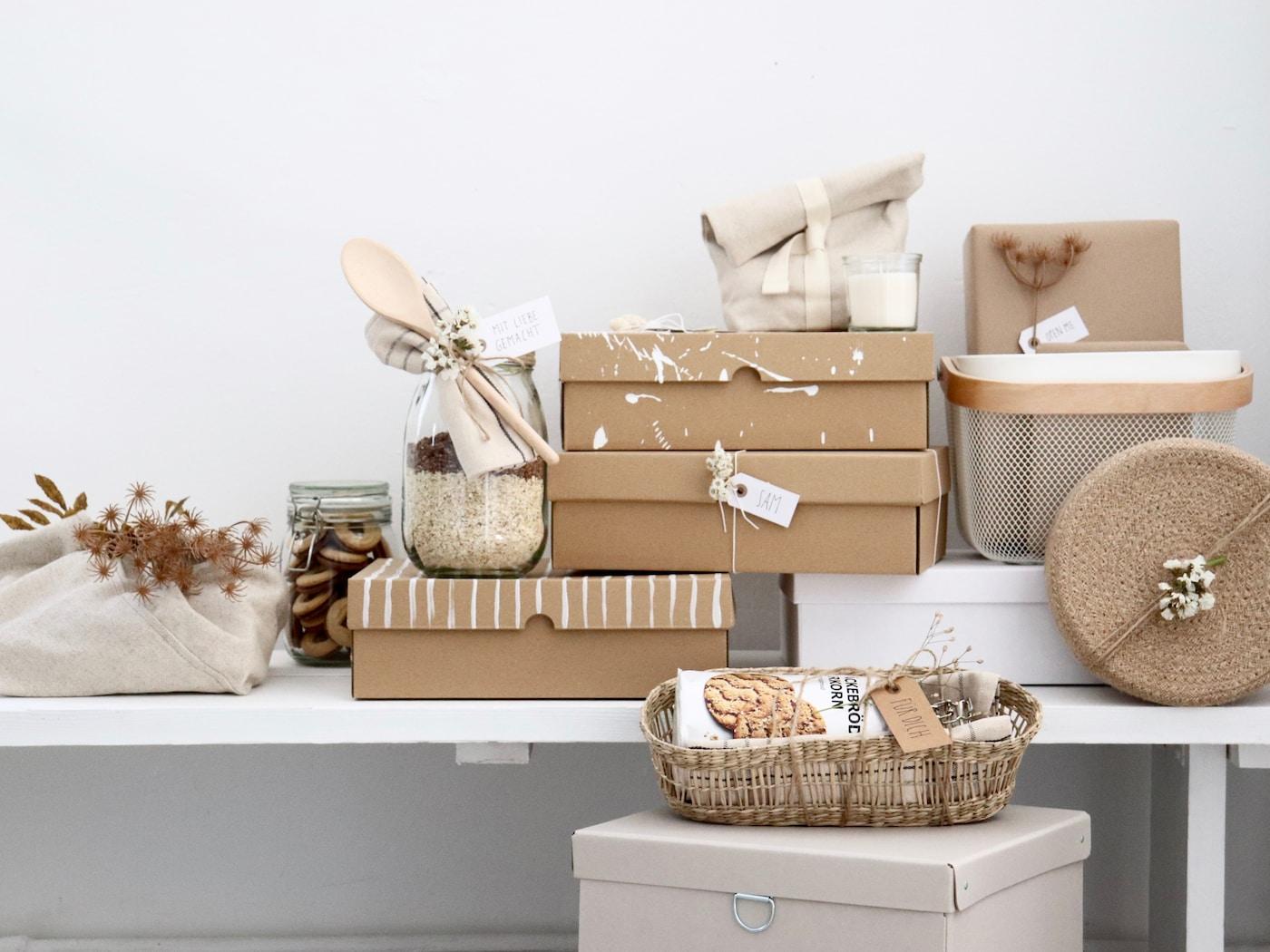 Es ist eine Zusammenstellung verschiedener Geschenkideen zu sehen, die in Naturtönen unterschiedlich verpackt sind. 