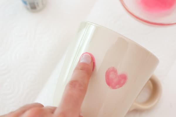 Es werden Blumenblüten mit Hilfe von Fingerabdrücken gemalt. Dabei wird der Abdruck jeweis in beide RIchtungen schräg aufgedrückt sodass ein Herzmuster entsteht.