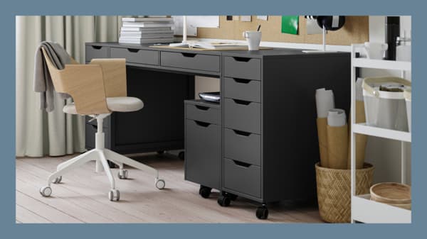 Escritorio IKEA con dos cajones y en cada cstado cajoneras con ruedas.