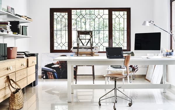 Espace bureau blanc avec commode en bois et tablettes.