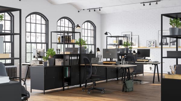 Espace de bureau paysager lumineux, divisé par des armoires et étagères ouvertes TROTTEN noires garnies de plantes, dossiers et boîtes.
