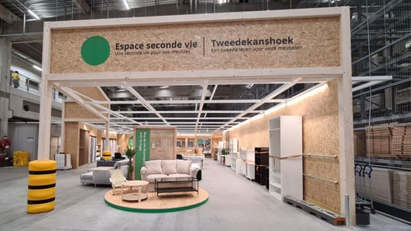 Espace seconde vie pour meubles, avec canapés et étagères exposés dans un entrepôt moderne et organisé.