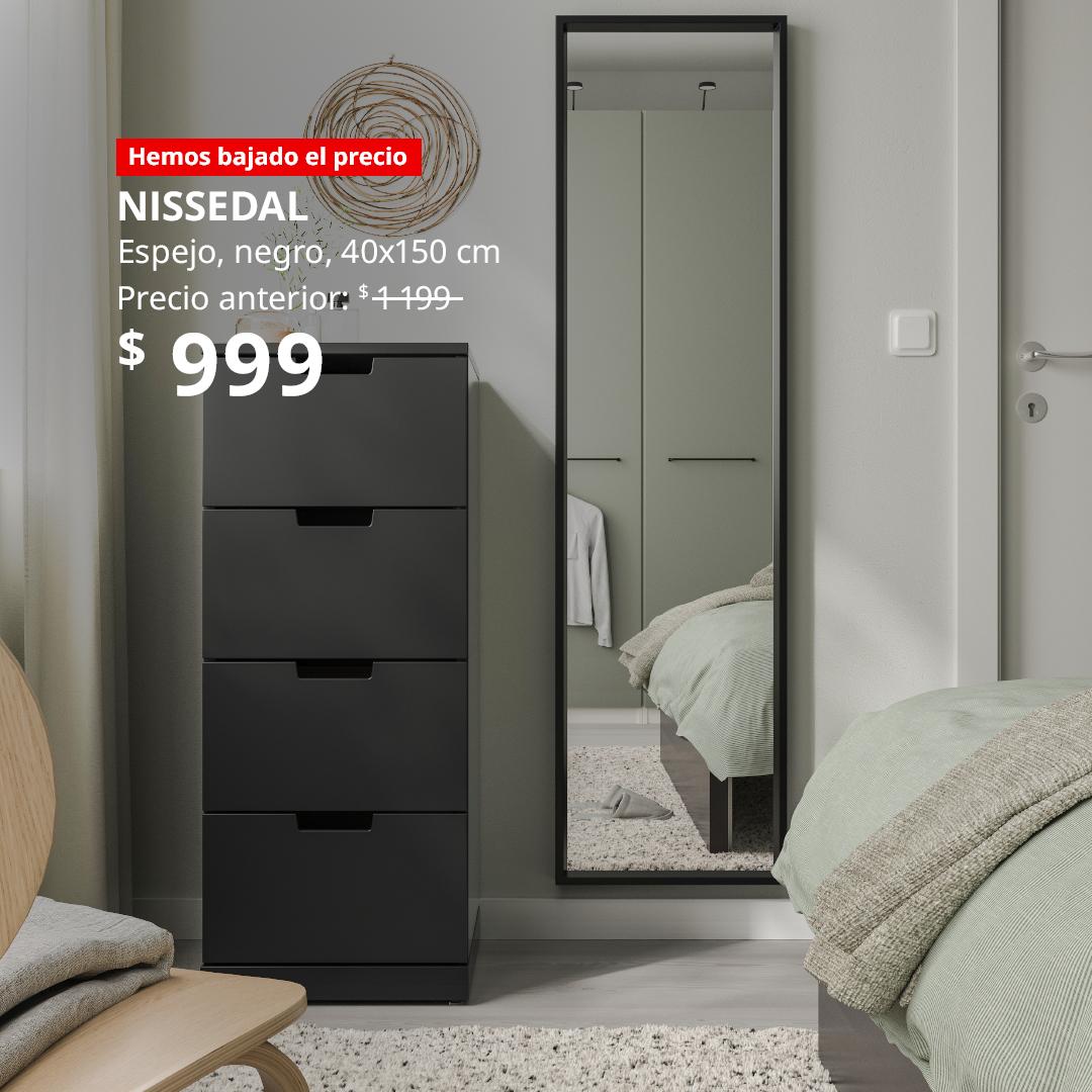 Espejo NISSEDAL negro colocado en un dormitorio, junto a una cómoda. 