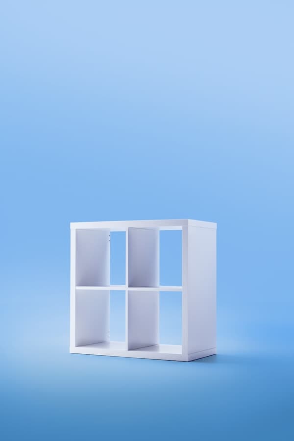 Estante de la serie KALLAX de color blanco, atrás un fondo celeste.