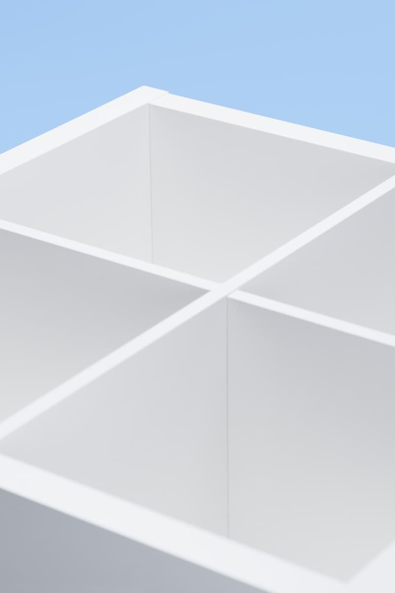 Estante de la serie KALLAX de color blanco, atrás un fondo celeste.