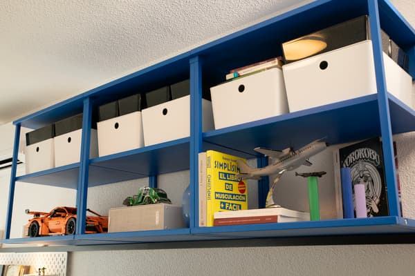 Estantería azul con cajas y objetos.