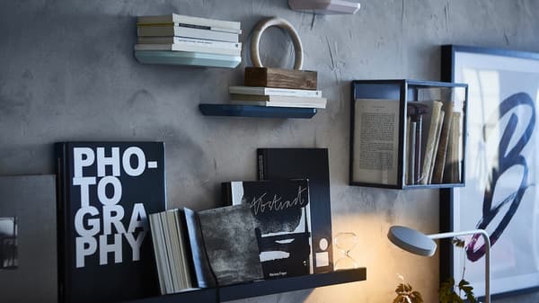 Estantes con libros e minivitrina sobre un muro escuro