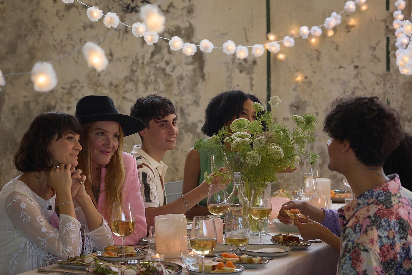 Et bord dekket opp til fest med flere gjester i godt humør.