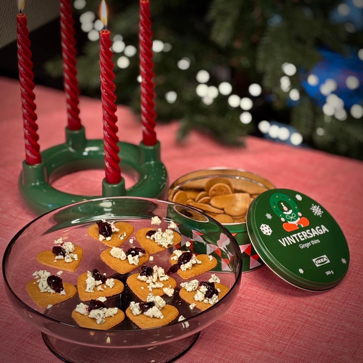 Et fad med brunkager med blåskimmelost og marmelade står ved siden af en grøn adventsstage med røde snoede lys.