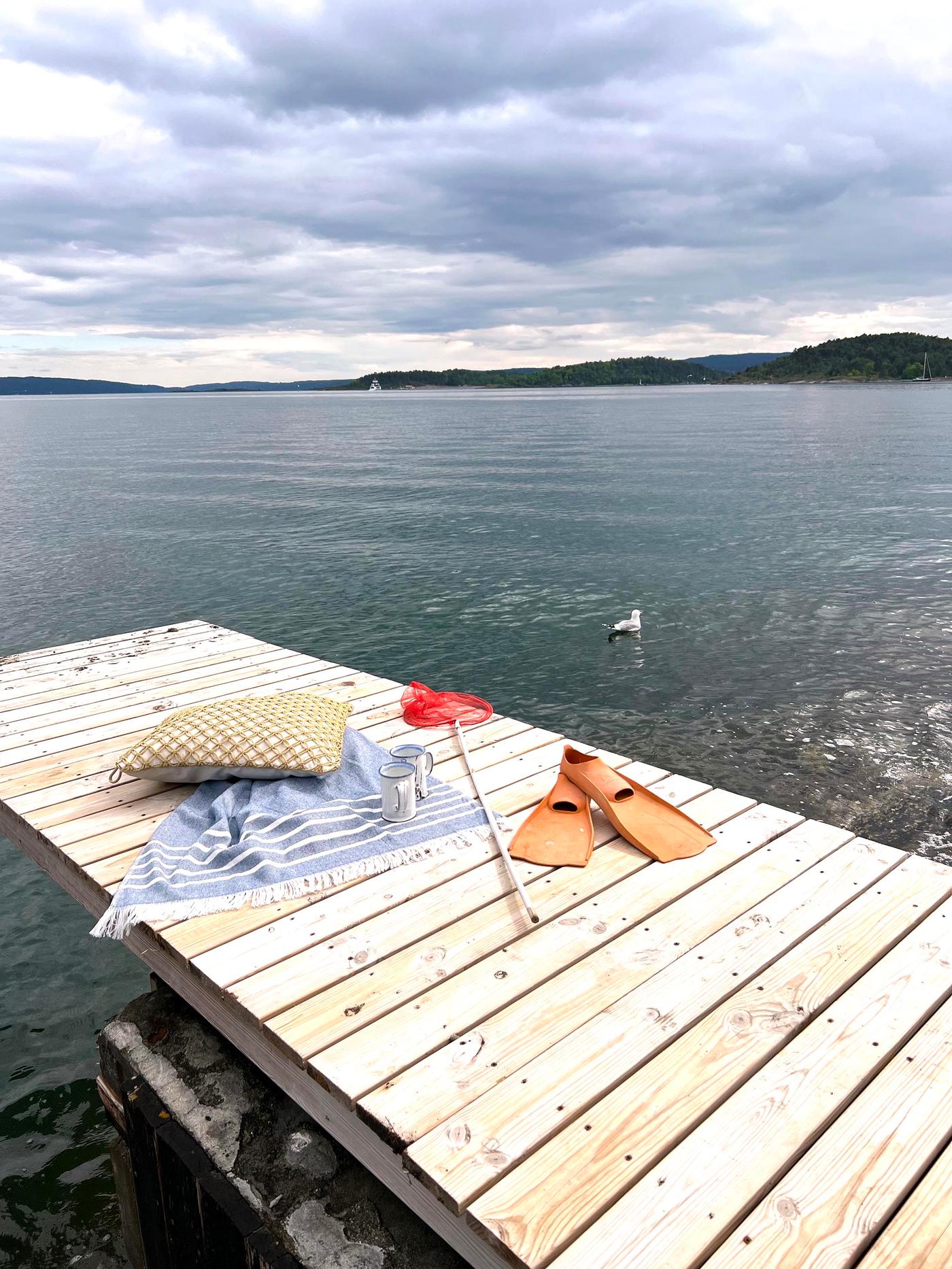 Et håndkle ligger ute på brygga.