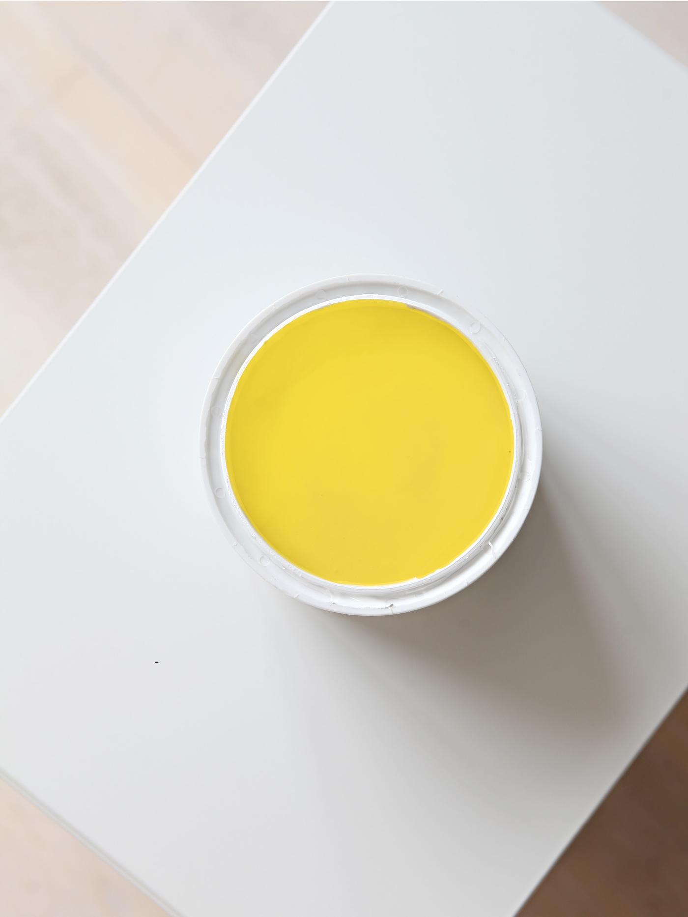 Et malingspann med gul maling.