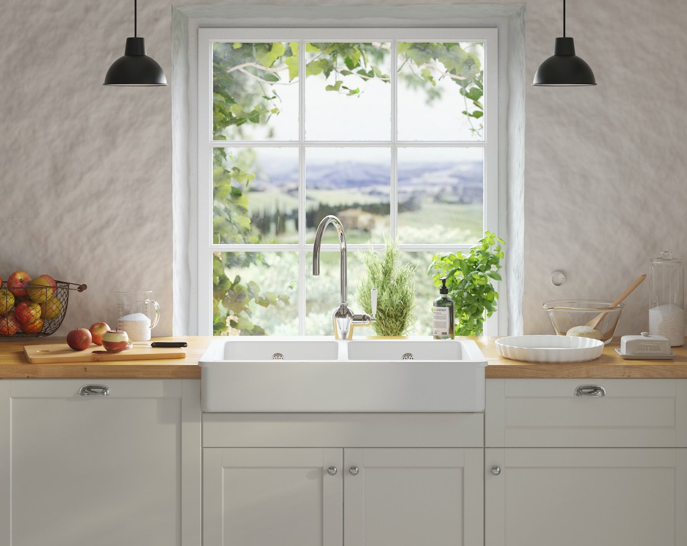 Et nærbillede af en håndvask med ting og sager omkring på køkkenbord foran et vindue med udsigt over et landskab.