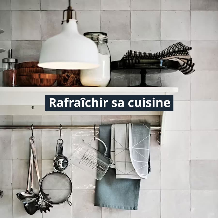 Etagère de cuisine accrochée au mur avec des ustensiles de cuisine suspendues sur un rail en acier.