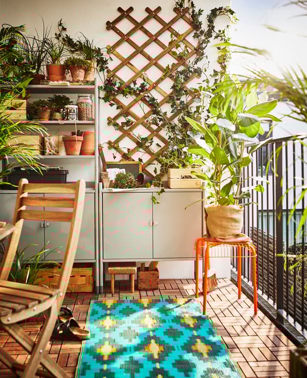 Étagère installée sur un balcon pour servir de rangement et de pôle jardinage.