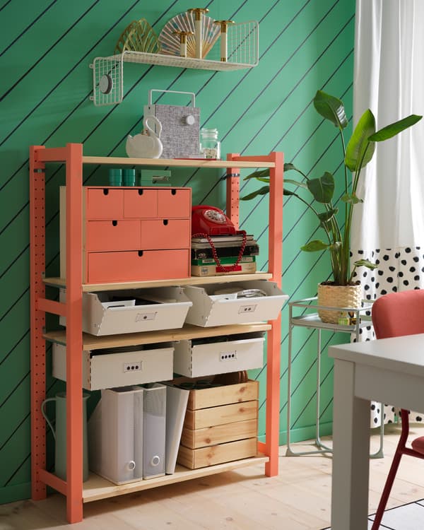 Étagère IVAR avec tiroirs blancs, étagère murale blanche, rideaux blancs et support pour plantes vertes.