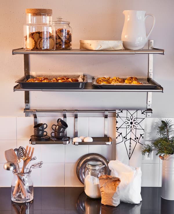 Étagères et rangements au-dessus d’un plan de travail où sont préparés des ingrédients pour de la pâtisserie.