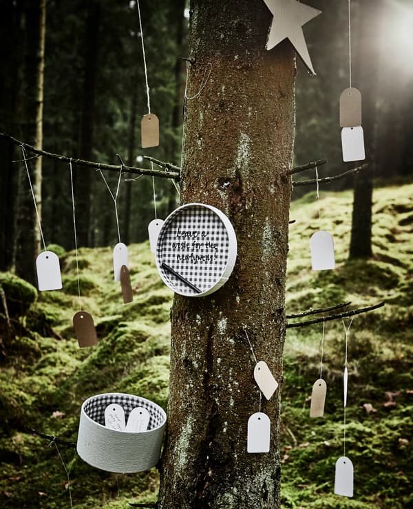 Étiquettes cadeau accrochées à un arbre, que les invités peuvent utiliser pour écrire un message puis placer dans une boîte en guise de livre d’or