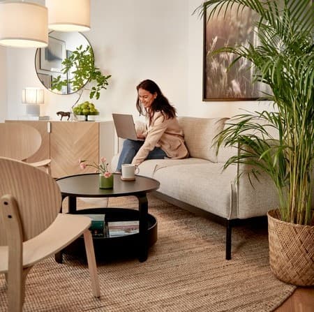 Ett kontor med en kvinna som sitter ner på soffa.