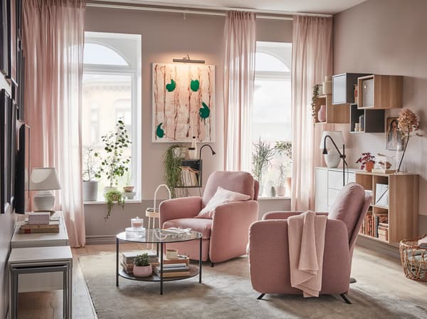 Ett vardagsrum med två EKOLSUND vilfåtöljer med ljust brunrosa GUNNARED klädsel som står framför fönster som släpper in dagsljus.