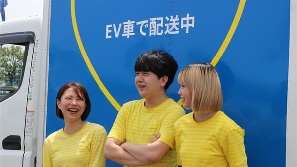 EV車の前でコワーカー3人が楽しそうに話している