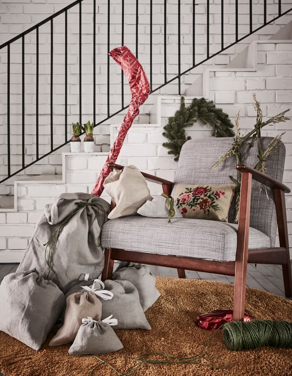 Fabric gift bags in different sizes are placed next to an armchair.